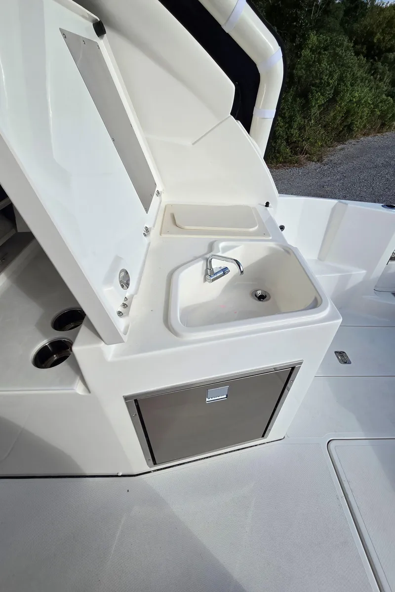 Slide: The Image of 2025 Pursuit DC 326 boat sink and storage area. - 9