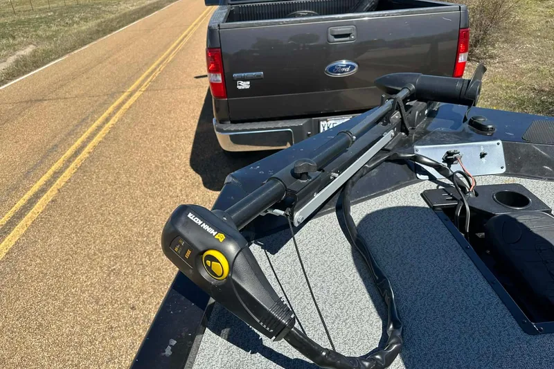 Slide: The Image of 2020 G3 Sportsman 1610 Camo boat with Minn Kota trolling motor on a road. - 13
