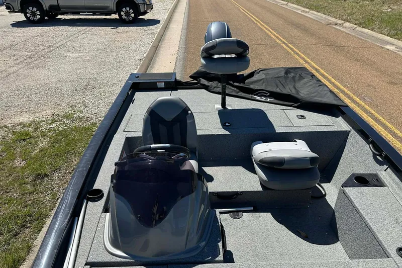 Slide: The Image of 2020 G3 Sportsman 1610 Camo boat interior with seating and steering wheel on a sunny day. - 19