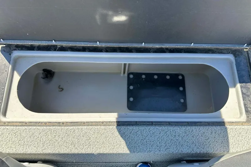 Slide: The Image of 2020 G3 Sportsman 1610 Camo boat storage compartment, open and empty. - 23