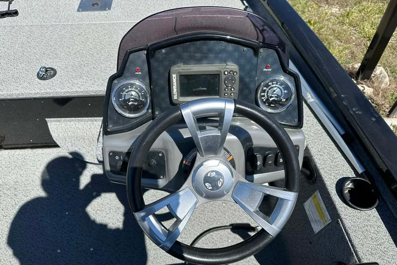 Slide: The Image of 2020 G3 Sportsman 1610 Camo boat dashboard with steering wheel and navigation controls. - 3