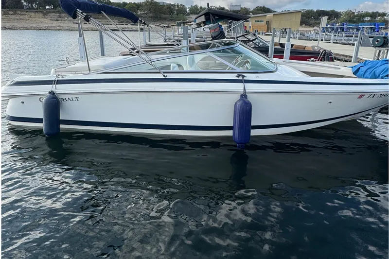 The Image of 2000 Cobalt 226 boat docked on calm water with blue fenders. - 1