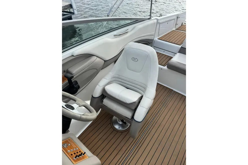 Slide: The Image of Captain's seat on a 2000 Cobalt 226 boat with teak flooring and steering wheel. - 10