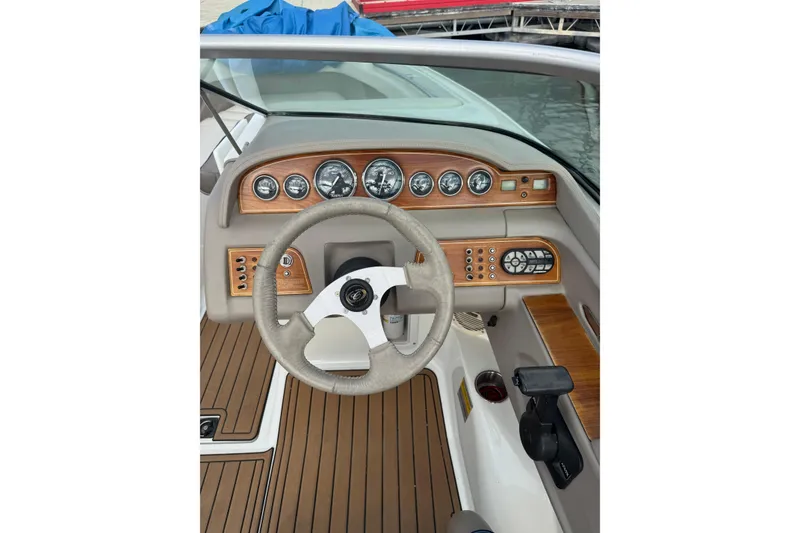 Slide: The Image of Steering wheel and dashboard of a 2000 Cobalt 226 boat, featuring wood accents and gauges. - 12