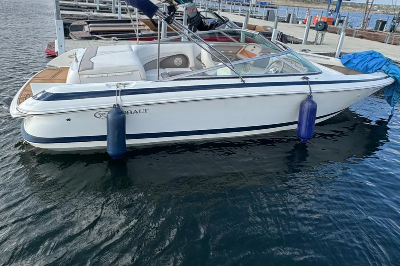 Slide: The Image of 2000 Cobalt 226 boat docked at marina, featuring sleek design and white exterior. - 3