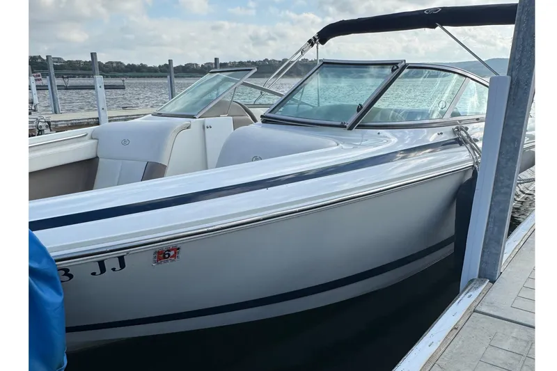 Slide: The Image of 2000 Cobalt 226 boat docked by the water on a sunny day. - 4