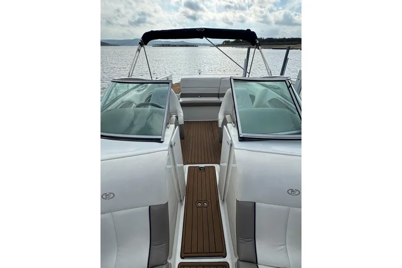 Slide: The Image of Cobalt 226 boat interior, 2000 model, featuring white seating and wooden flooring on a calm lake. - 9