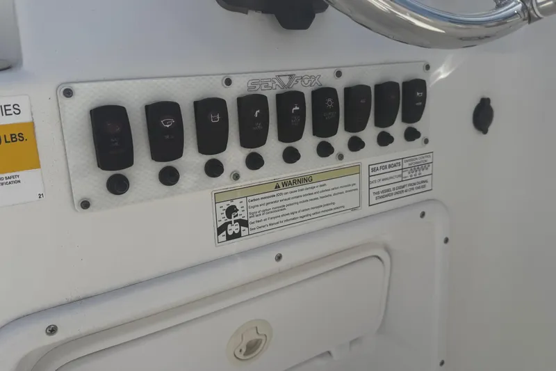 Slide: The Image of Control panel of a 2012 Sea Fox 216 Dual Console boat with warning labels. - 26