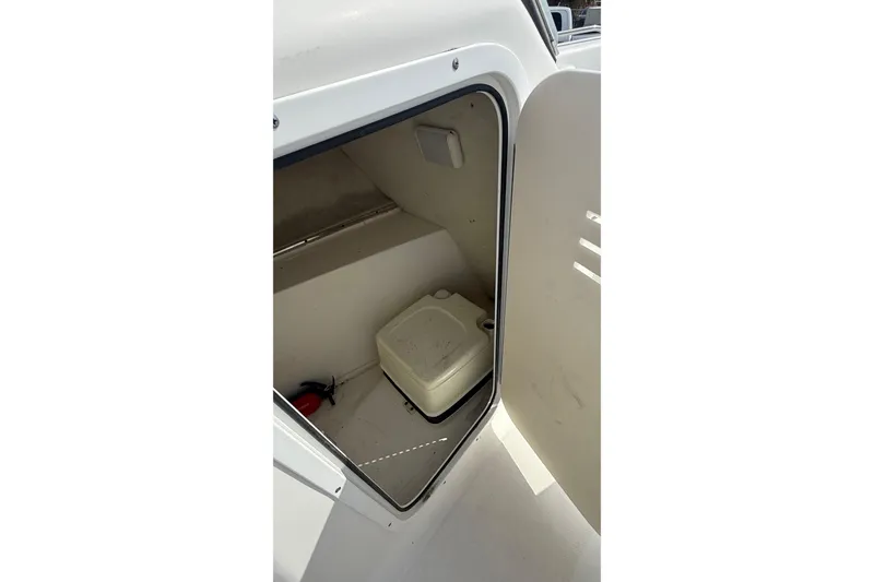 Slide: The Image of 2012 Sea Fox 216 Dual Console boat interior storage compartment with portable toilet. - 28