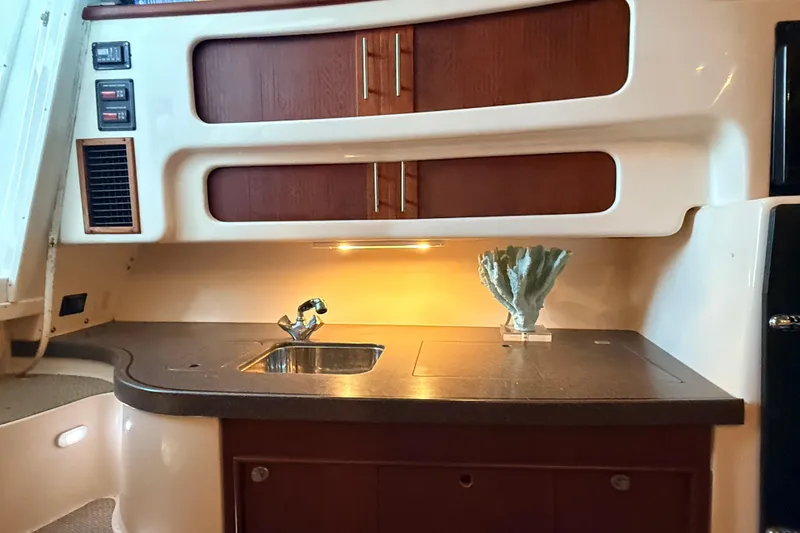 Slide: The Image of 2008 Grady-White Express 360 boat interior with sink and wooden cabinets. - 13