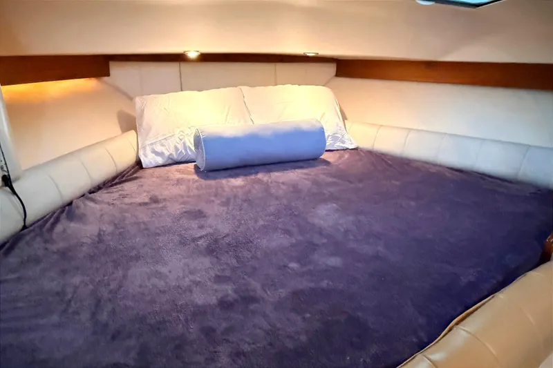 Slide: The Image of Cozy cabin bed in 2008 Grady-White Express 360 boat, featuring plush bedding and ambient lighting. - 16