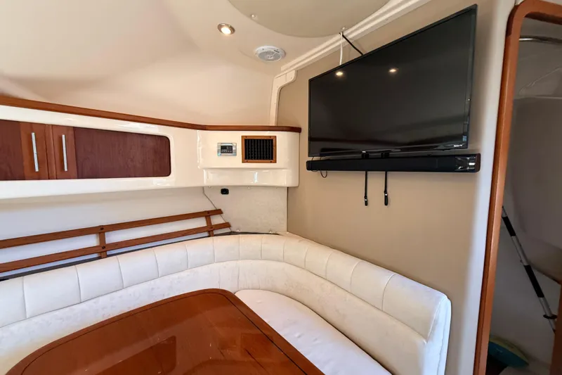 Slide: The Image of Interior of 2008 Grady-White Express 360 with TV, seating, and wooden cabinetry. - 17