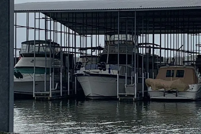 The Image of 1976 Hatteras 43 Double Cabin yacht docked in a covered marina. - 0