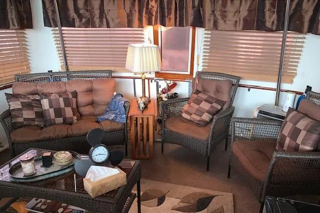 Slide: The Image of Cozy interior of 1976 Hatteras 43 Double Cabin with wicker furniture and soft lighting. - 10