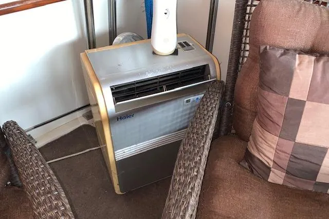 Slide: The Image of Portable Haier air conditioner on 1976 Hatteras 43 Double Cabin yacht, surrounded by wicker furniture. - 11