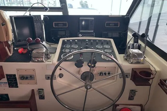 Slide: The Image of 1976 Hatteras 43 Double Cabin helm with steering wheel, gauges, and navigation equipment. - 13