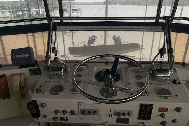 Slide: The Image of 1976 Hatteras 43 Double Cabin helm with steering wheel and navigation controls. - 16
