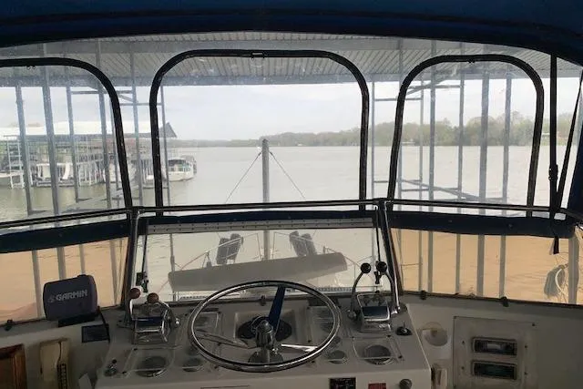 Slide: The Image of 1976 Hatteras 43 Double Cabin helm view with marina backdrop. - 17