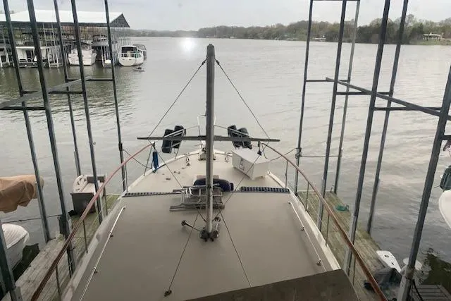 Slide: The Image of 1976 Hatteras 43 Double Cabin yacht docked on a serene lake. - 18