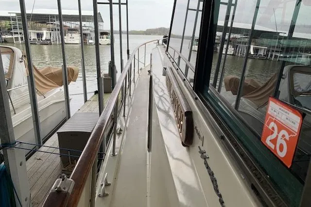 Slide: The Image of 1976 Hatteras 43 Double Cabin yacht docked at marina, side view with railing. - 2