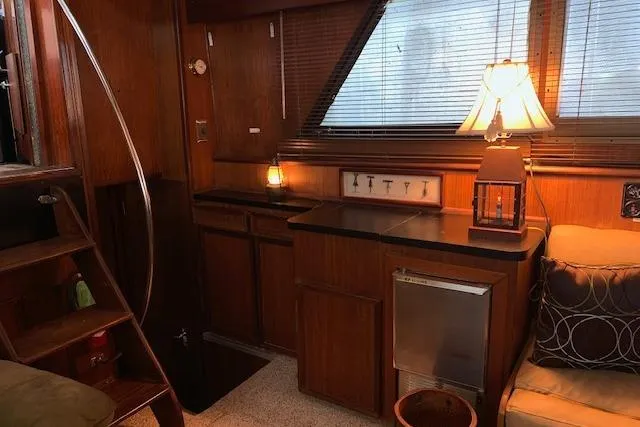 Slide: The Image of Interior of 1976 Hatteras 43 Double Cabin with wood paneling and cozy lighting. - 24