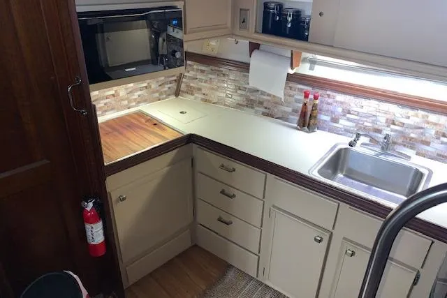Slide: The Image of 1976 Hatteras 43 Double Cabin kitchen with modern appliances and stylish backsplash. - 27