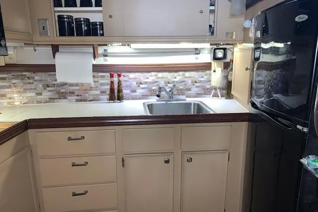Slide: The Image of 1976 Hatteras 43 Double Cabin kitchen with sink, cabinets, and backsplash. - 28