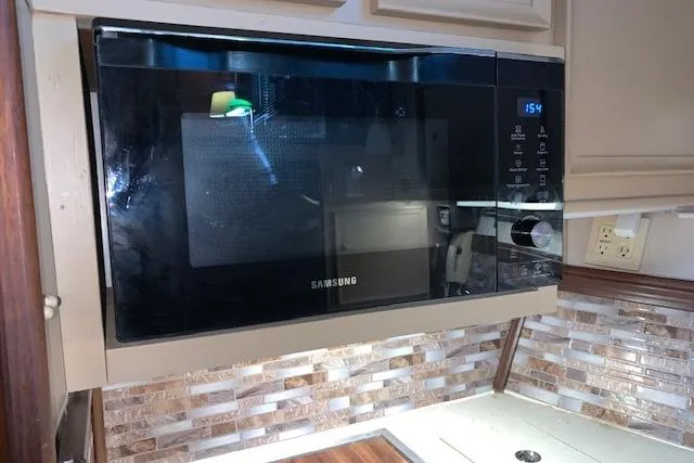 Slide: The Image of Samsung microwave in a 1976 Hatteras 43 Double Cabin kitchen with tiled backsplash. - 30