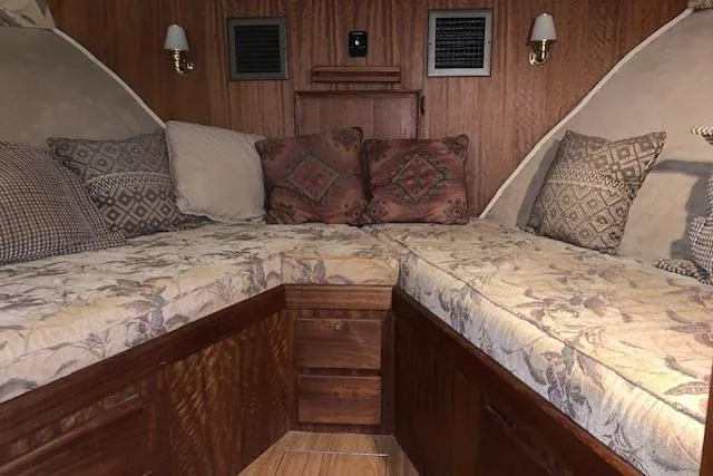 Slide: The Image of Cozy cabin interior of 1976 Hatteras 43 Double Cabin with patterned cushions and wood paneling. - 32