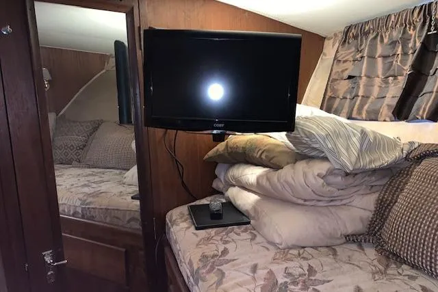Slide: The Image of Cozy cabin interior of 1976 Hatteras 43 Double Cabin with TV and bedding. - 33
