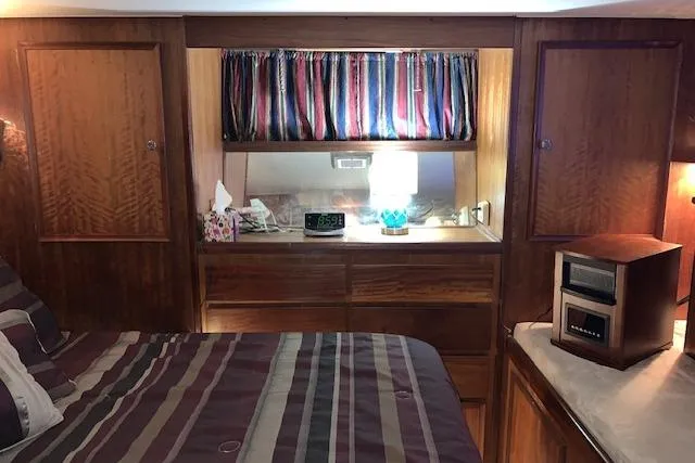 Slide: The Image of 1976 Hatteras 43 Double Cabin interior with wood paneling and striped bedding. - 36