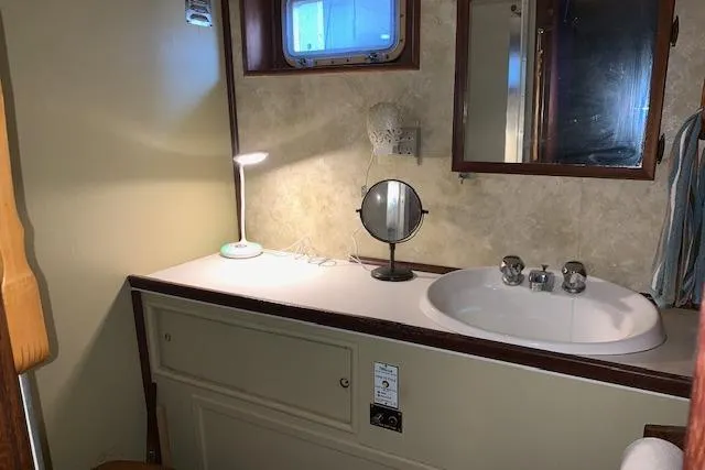 Slide: The Image of 1976 Hatteras 43 Double Cabin bathroom with sink, mirror, and lamp. - 40