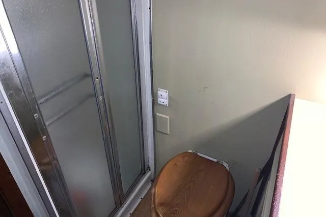 Slide: The Image of Bathroom interior of 1976 Hatteras 43 Double Cabin with shower and wooden toilet seat. - 42