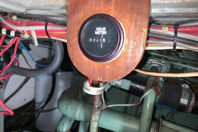 Slide: The Image of Hour meter in 1976 Hatteras 43 Double Cabin engine room with wiring and pipes. - 44