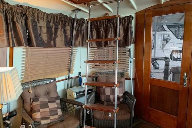 Slide: The Image of Interior of 1976 Hatteras 43 Double Cabin with cozy seating and wooden ladder. - 7