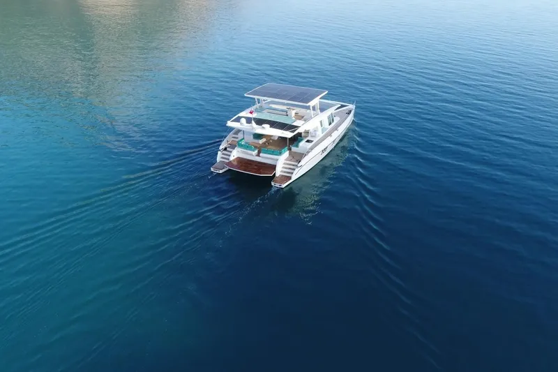 Slide: The Image of Aerial view of 2018 Serenity 64 yacht cruising on calm blue waters. - 1