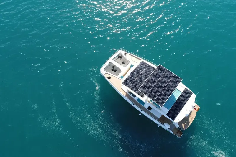 Slide: The Image of Aerial view of 2018 Serenity 64 yacht with solar panels on blue ocean. - 2
