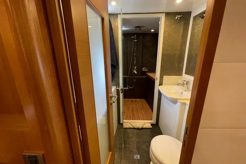 Slide: The Image of Modern yacht bathroom with shower, sink, and toilet in a 2018 Serenity 64 model. - 39
