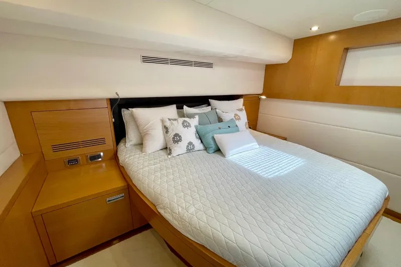 Slide: The Image of Luxurious bedroom interior on 2018 Serenity 64 yacht, featuring elegant bedding and wood accents. - 52