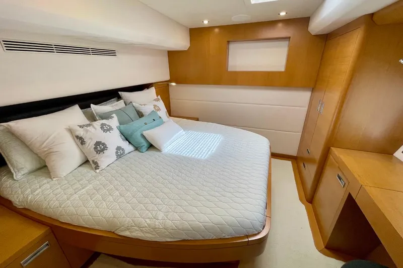 Slide: The Image of Luxurious bedroom interior on 2018 Serenity 64 yacht, featuring elegant bedding and wooden cabinetry. - 53
