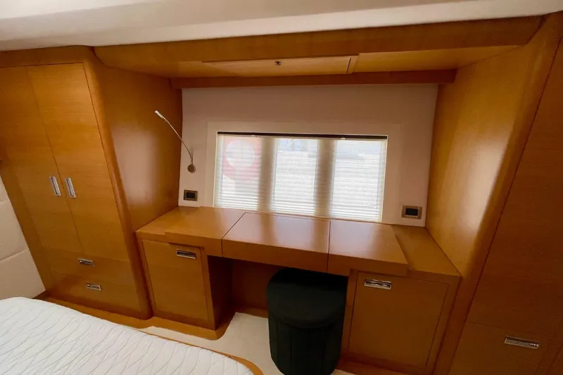 Slide: The Image of Luxurious wooden interior of 2018 Serenity 64 yacht cabin with desk and window. - 54