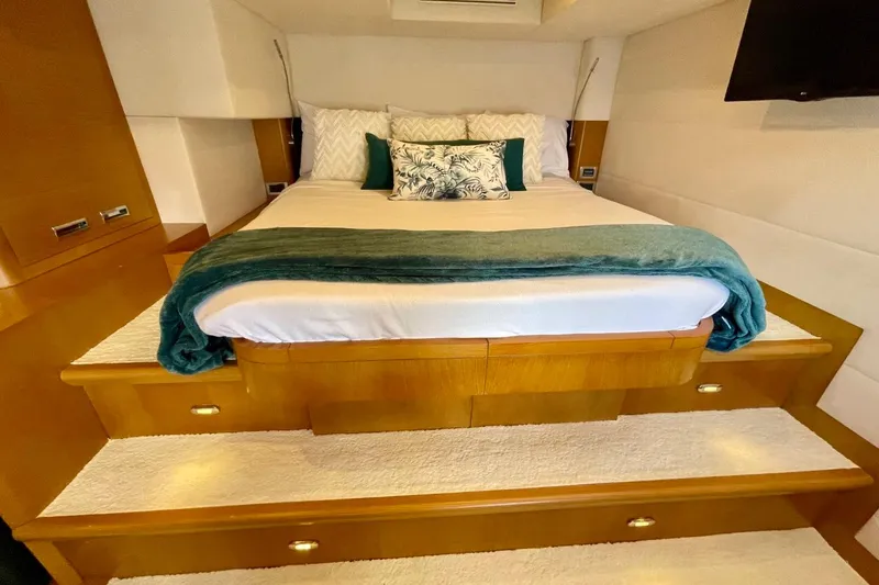 Slide: The Image of Luxurious bedroom interior on Serenity 64 yacht, featuring elegant bedding and wooden accents. - 57