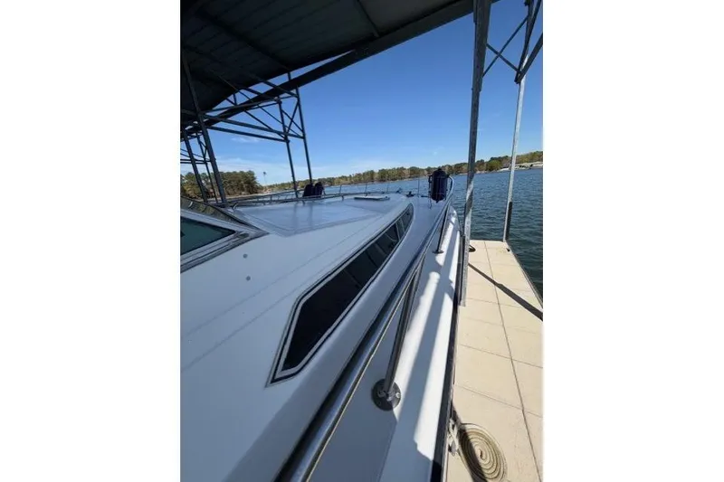 Slide: The Image of 1989 Sea Ray 460 Express Cruiser docked, showcasing sleek design and waterfront view. - 11