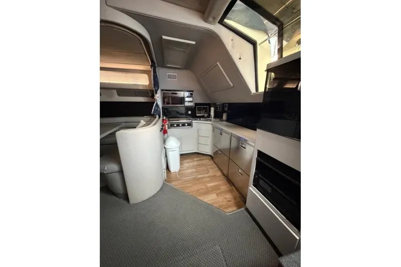 Slide: The Image of Interior of 1989 Sea Ray 460 Express Cruiser with modern kitchen amenities. - 16