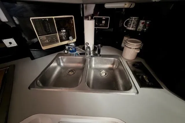 Slide: The Image of 1989 Sea Ray 460 Express Cruiser kitchen with dual sinks and control panels. - 17