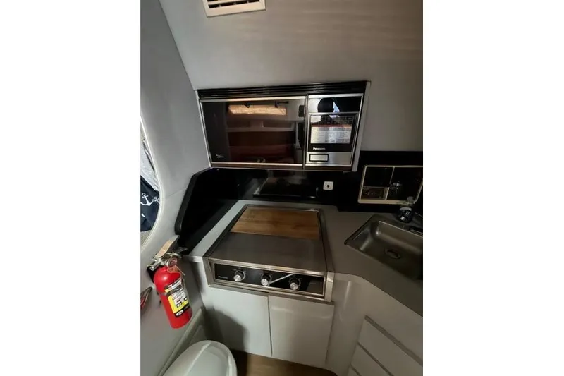 Slide: The Image of Compact kitchen area in a 1989 Sea Ray 460 Express Cruiser with stove, microwave, and sink. - 18