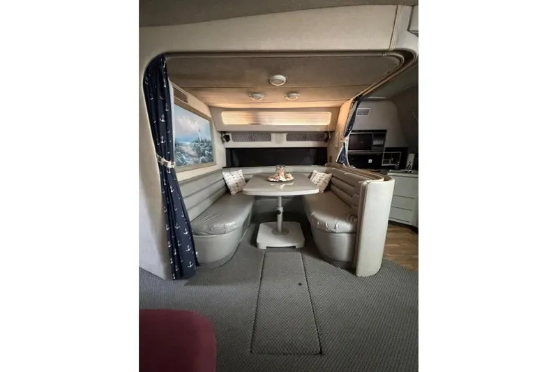 Slide: The Image of Interior of 1989 Sea Ray 460 Express Cruiser with cozy dining area and nautical decor. - 22