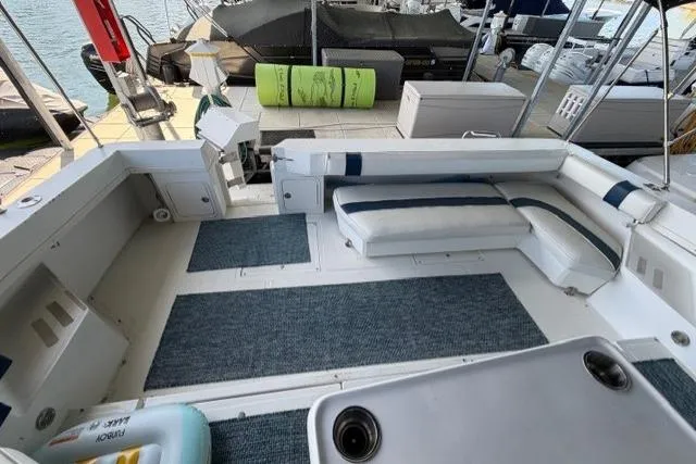 Slide: The Image of 1989 Sea Ray 460 Express Cruiser cockpit with seating and marine carpet at dock. - 8