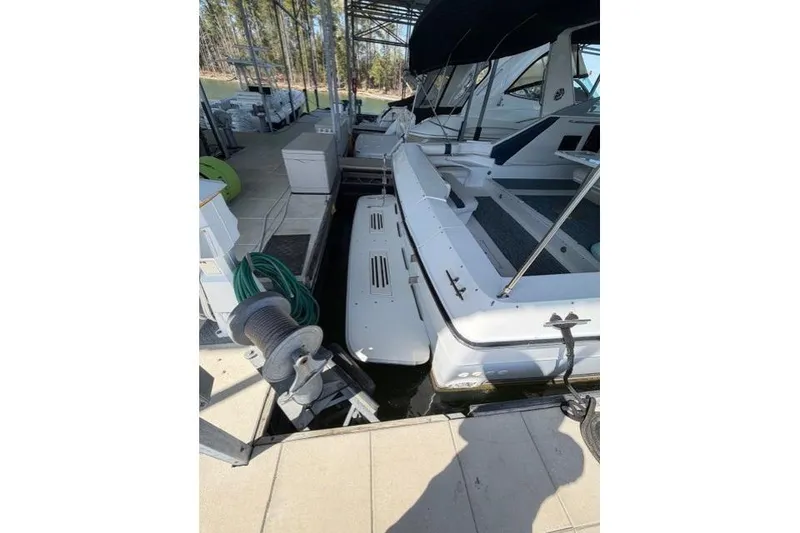 Slide: The Image of 1989 Sea Ray 460 Express Cruiser docked at marina, featuring spacious deck and mooring equipment. - 9