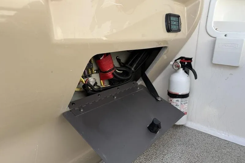 Slide: The Image of 2000 Chaparral Signature 240 boat compartment with fire extinguisher and electrical components. - 11